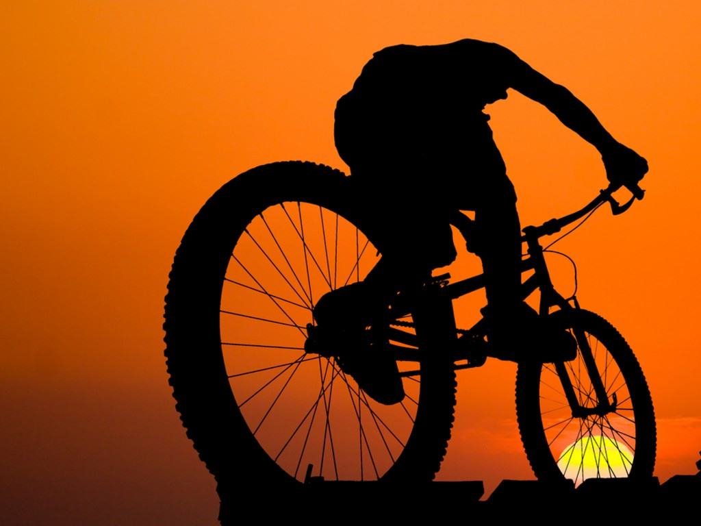 mountain_biker_silhouette_on_sea_sunset_background